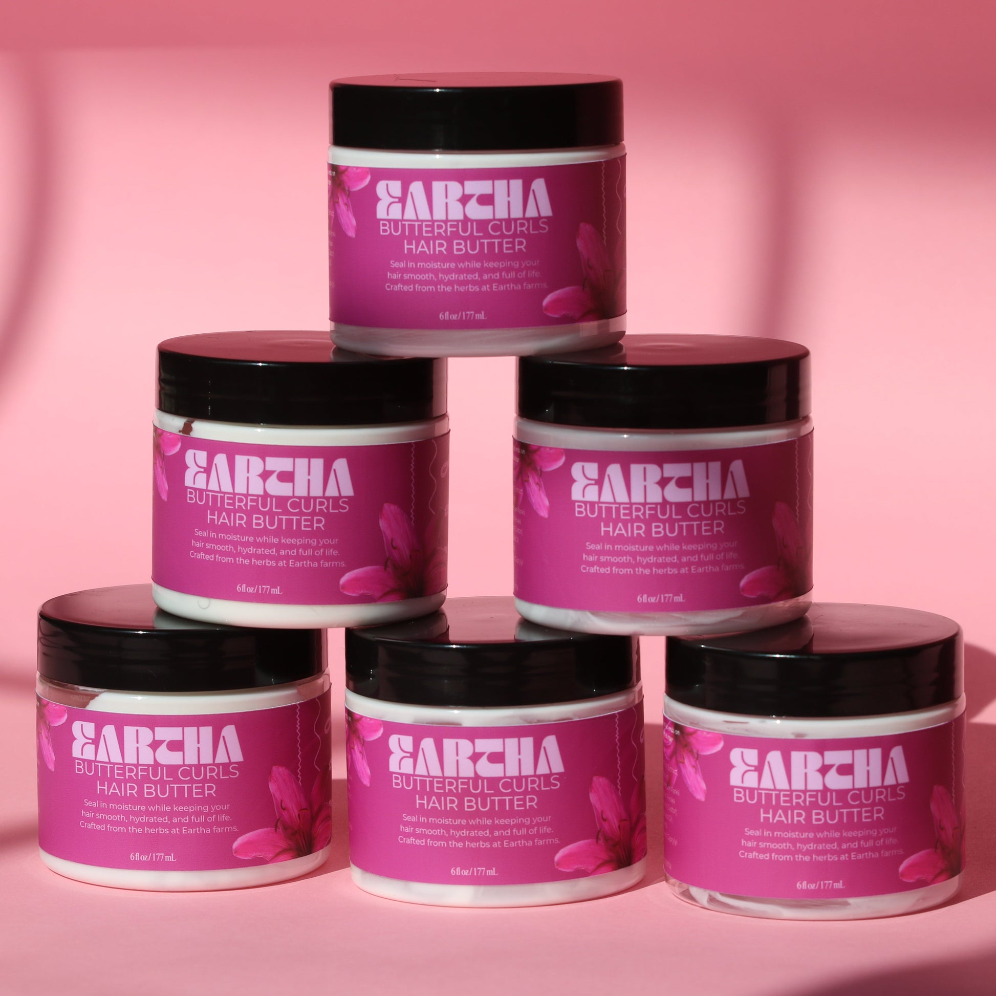 Eartha Butterful Curls Hair Butter 6oz jar on earthy linen background with dried botanicals